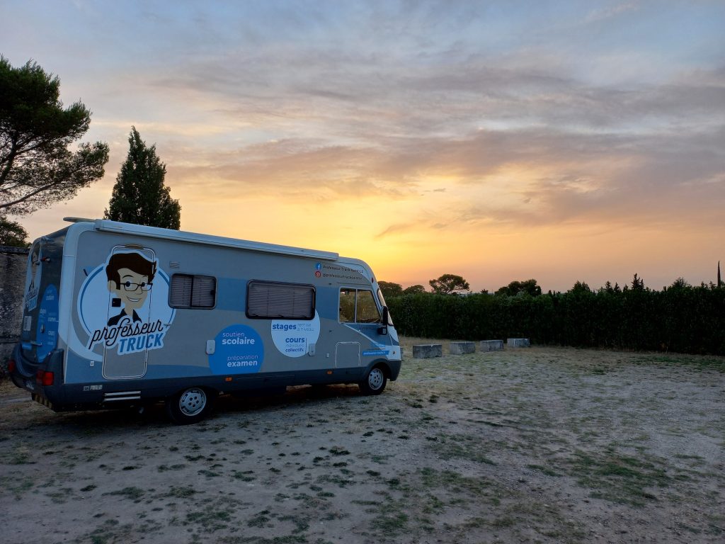 Le Professeur Truck de Saint-Lô stationné en extérieur au coucher du soleil.