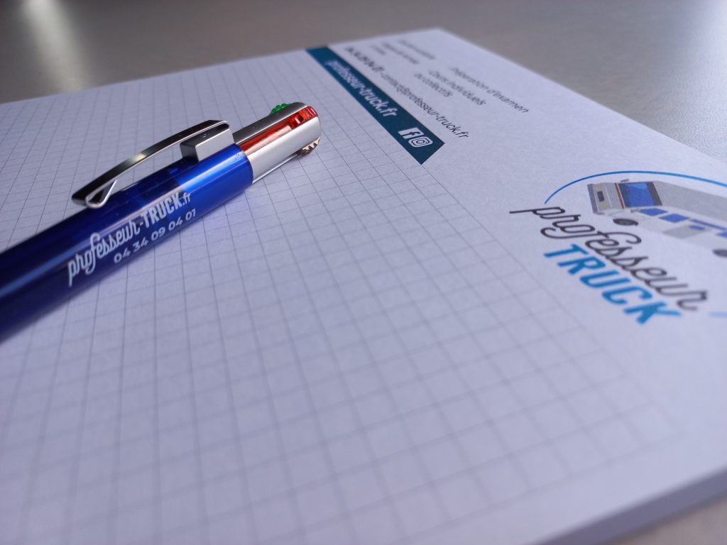 Un cahier et un stylo Professeur Truck prêts pour une séance de soutien scolaire.